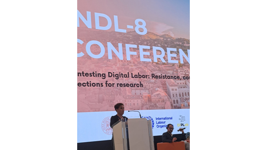 una persona su un palco parla da un leggìo