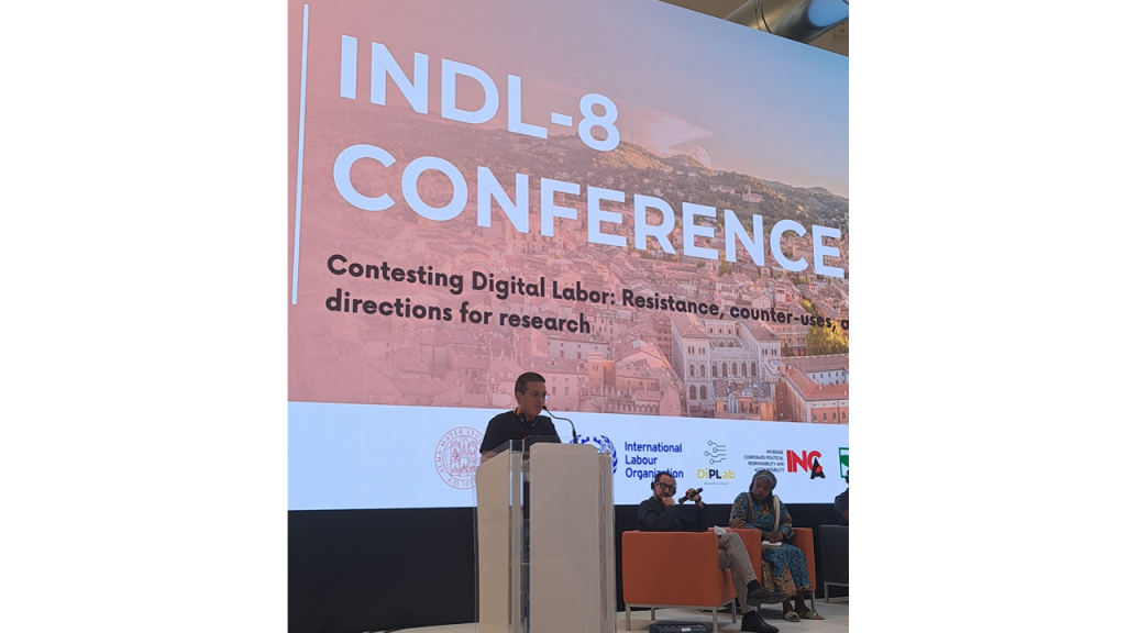 una persona su un palco parla da un leggìo